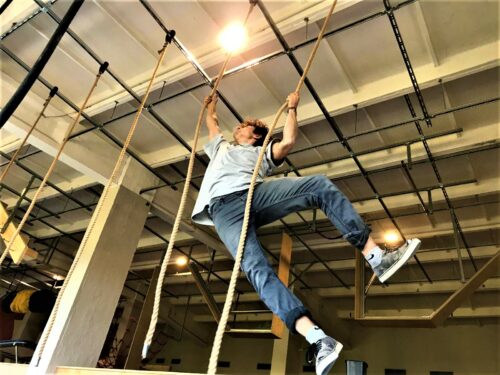 Kind, wie es akrobatisch an Seilen klettert